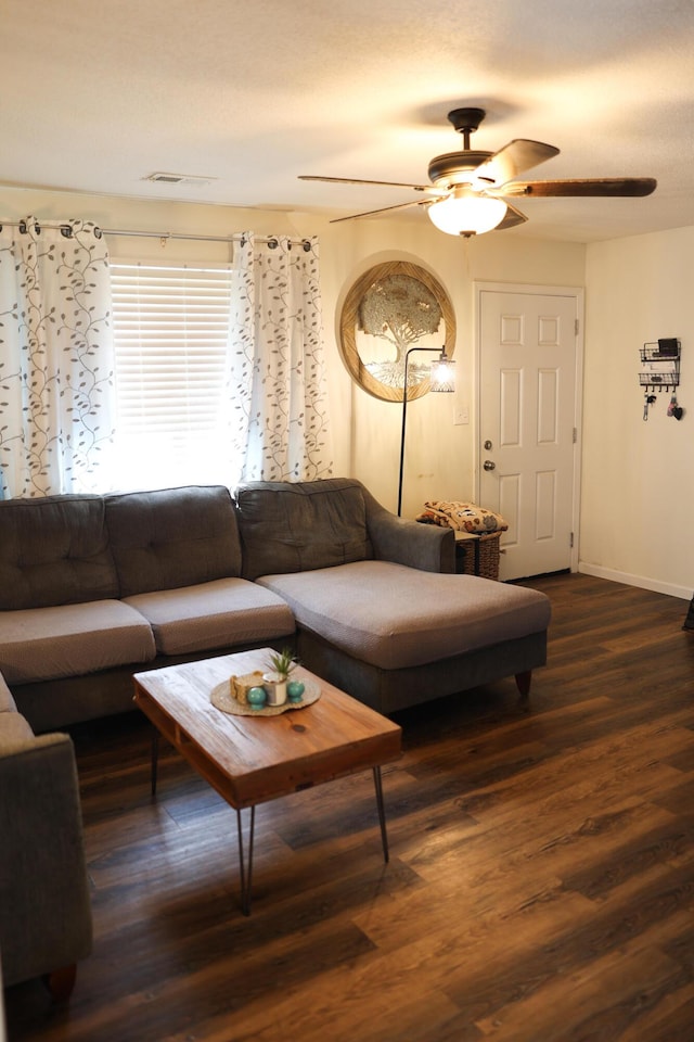 living area with visible vents, baseboards, a ceiling fan, and wood finished floors