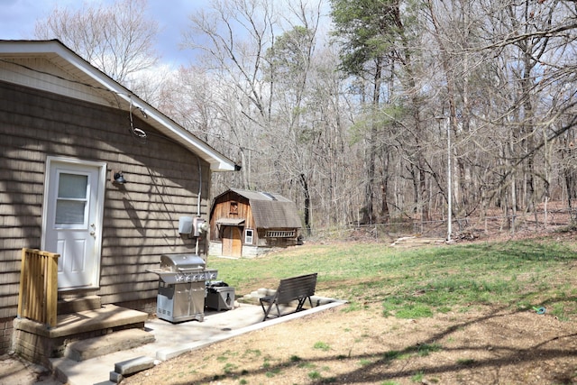 view of yard with entry steps, a storage unit, an outdoor structure, and fence