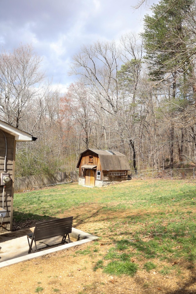 view of yard featuring a storage shed, an outdoor structure, and fence