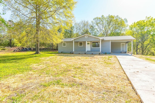 view of front of house with a carport, concrete driveway, and a front lawn