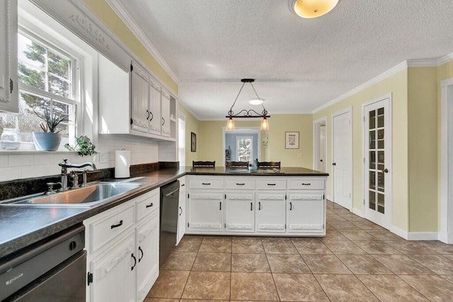 kitchen featuring dark countertops, dishwasher, black dishwasher, plenty of natural light, and a sink