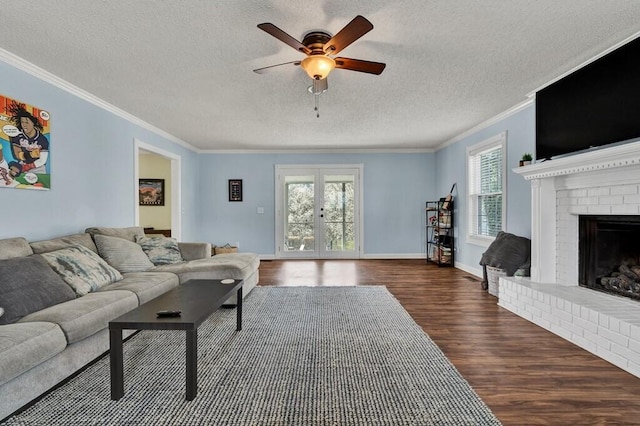living area featuring crown molding, a fireplace, french doors, a ceiling fan, and dark wood-style flooring