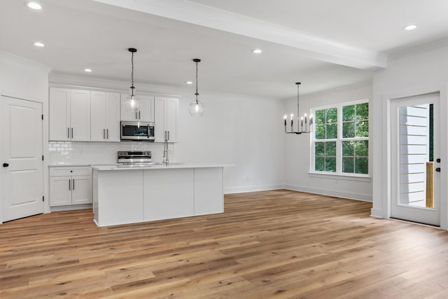 kitchen featuring decorative backsplash, appliances with stainless steel finishes, light wood-style floors, and ornamental molding