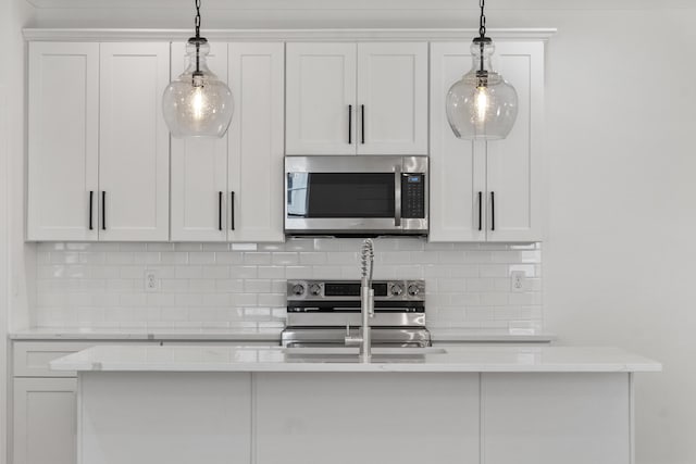 kitchen with backsplash, white cabinets, stainless steel appliances, and light countertops