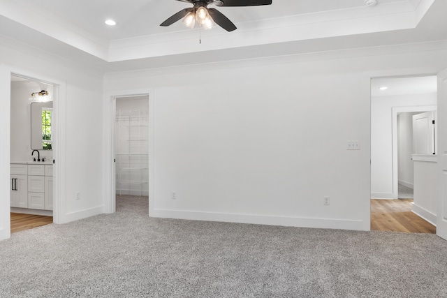 unfurnished bedroom featuring recessed lighting, baseboards, a raised ceiling, and carpet floors