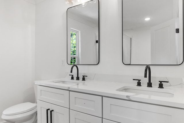 bathroom featuring a sink, toilet, and double vanity