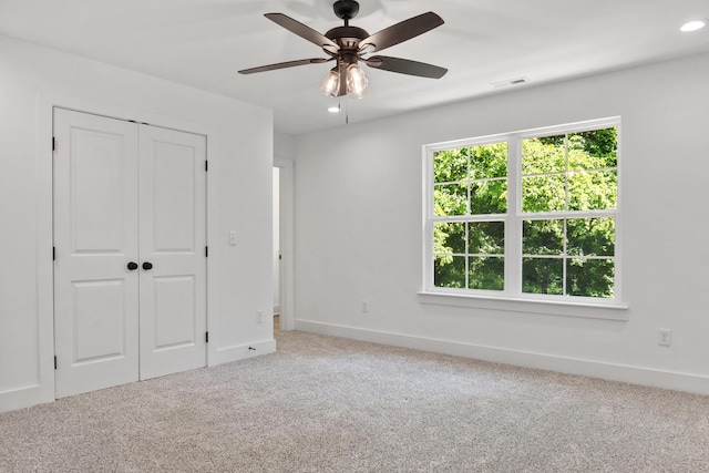 unfurnished bedroom featuring multiple windows, baseboards, visible vents, and carpet floors