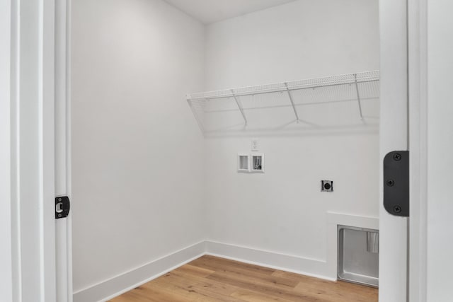 washroom featuring light wood-type flooring, washer hookup, baseboards, hookup for an electric dryer, and laundry area