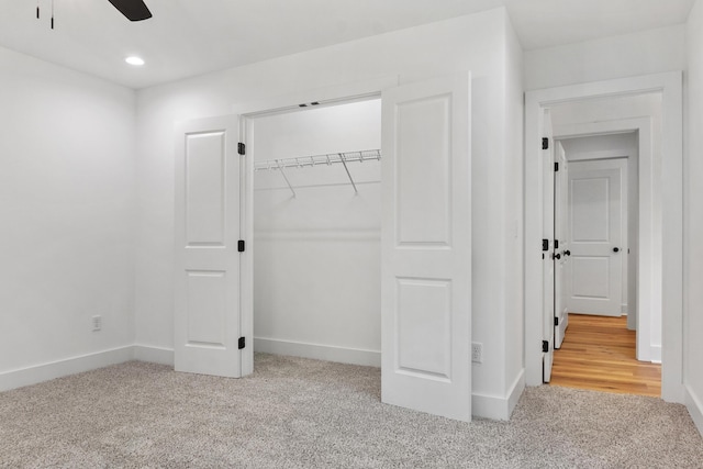 unfurnished bedroom featuring a closet, recessed lighting, baseboards, and carpet floors