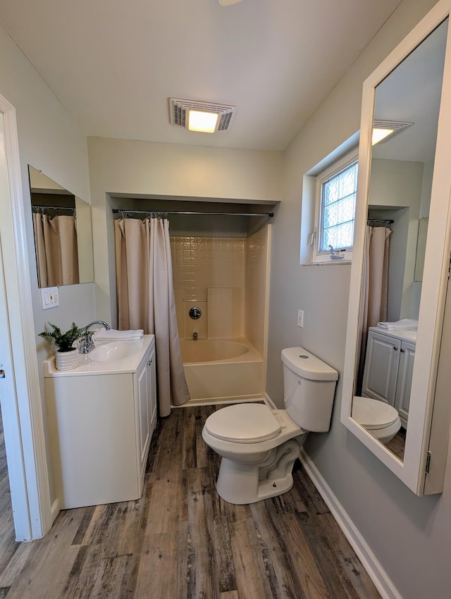 full bathroom with vanity, wood finished floors, visible vents, toilet, and shower / tub combo with curtain