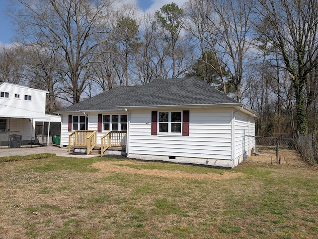 view of front facade featuring a front yard, fence, roof with shingles, and crawl space