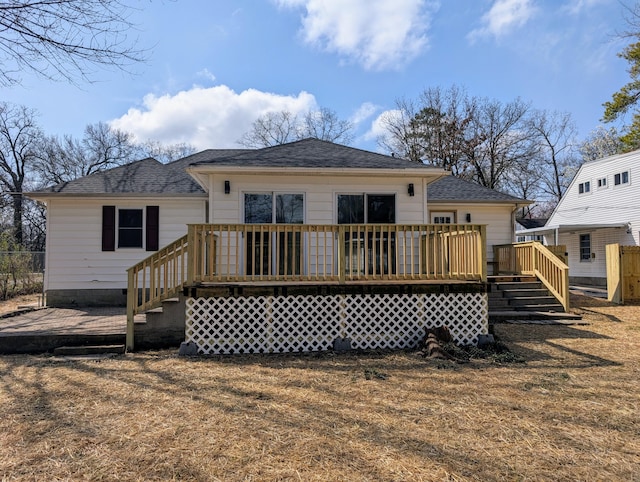 back of property featuring a wooden deck and roof with shingles