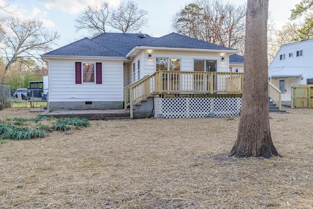 rear view of house featuring a deck, fence, roof with shingles, and crawl space