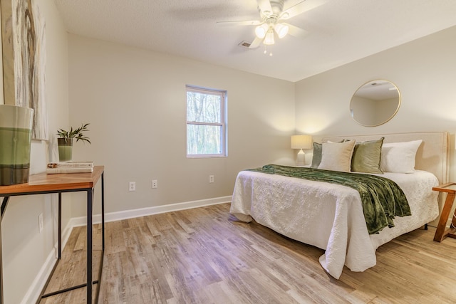 bedroom with visible vents, ceiling fan, baseboards, and light wood-style floors