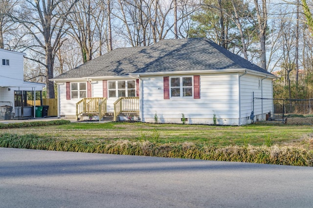 view of front of property featuring a shingled roof, a front yard, and fence