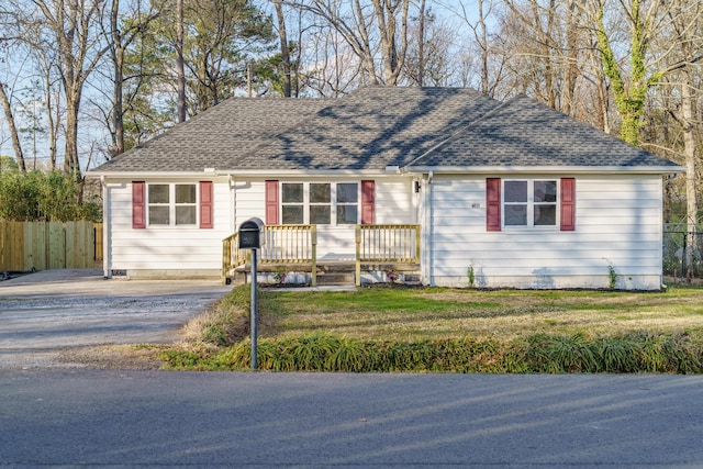 ranch-style home featuring crawl space, fence, a front lawn, and a shingled roof