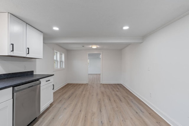 kitchen featuring dark countertops, white cabinets, baseboards, and stainless steel dishwasher