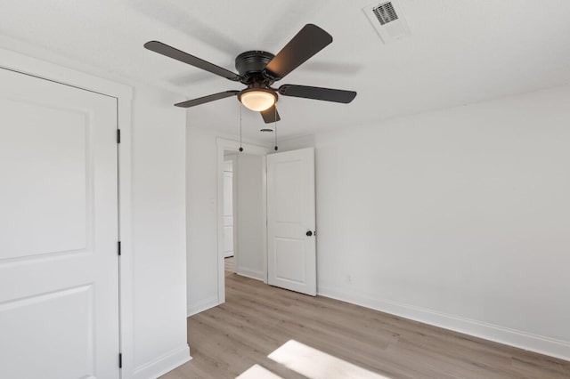 unfurnished bedroom with visible vents, light wood-style flooring, baseboards, and ceiling fan