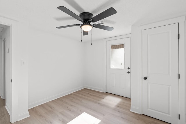 interior space featuring baseboards, light wood-type flooring, and ceiling fan