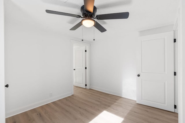 unfurnished bedroom featuring a ceiling fan, light wood-type flooring, and baseboards