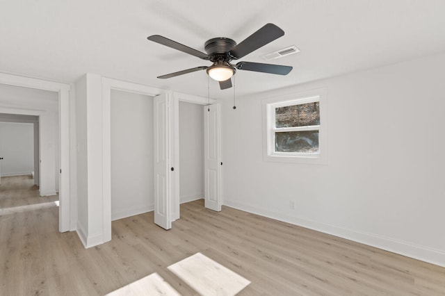 unfurnished bedroom with visible vents, light wood-style flooring, baseboards, and ceiling fan