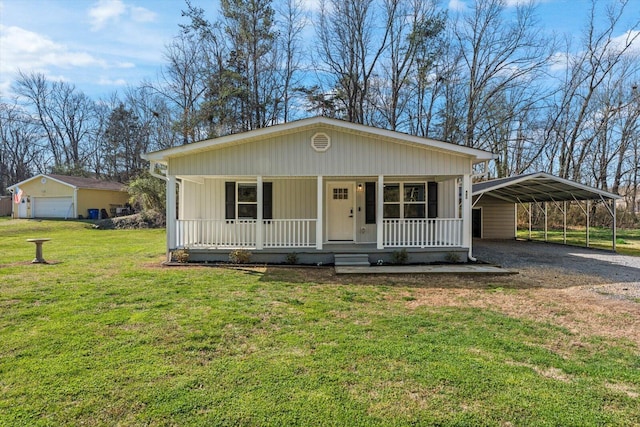 view of front of house with a detached carport, covered porch, driveway, and a front lawn