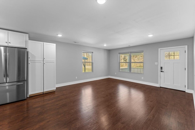 unfurnished living room with recessed lighting, baseboards, and dark wood-style floors