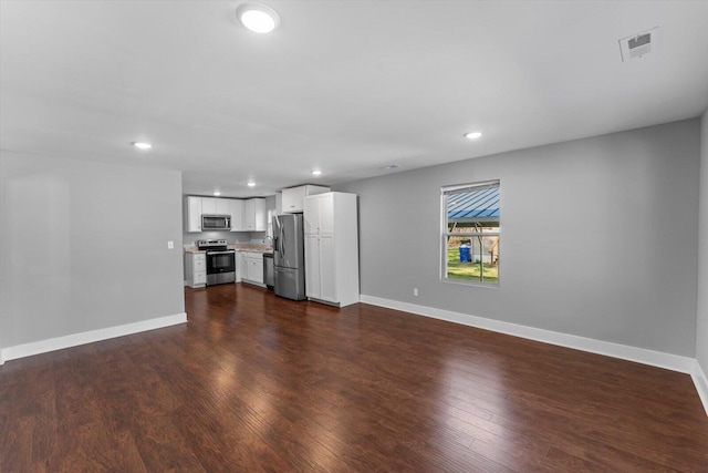 unfurnished living room featuring dark wood finished floors, visible vents, recessed lighting, and baseboards