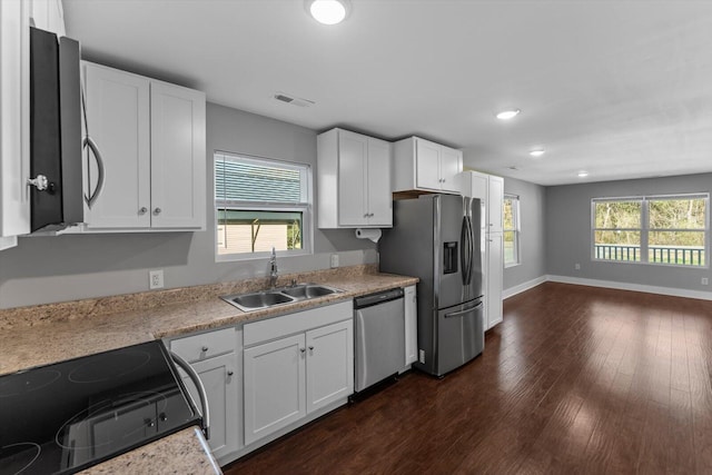 kitchen featuring a sink, light countertops, appliances with stainless steel finishes, white cabinets, and dark wood-style flooring