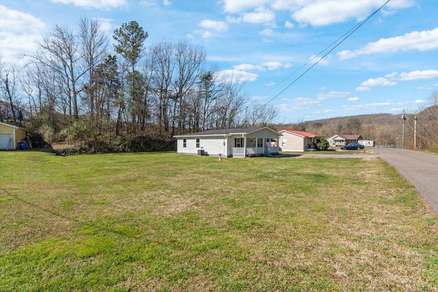 view of front of house with a front lawn, a porch, and driveway