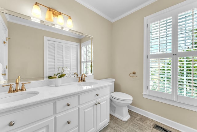 bathroom featuring toilet, ornamental molding, baseboards, double vanity, and tile patterned flooring