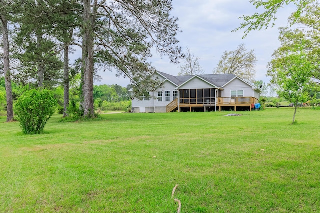 back of property featuring a wooden deck, a lawn, and a sunroom