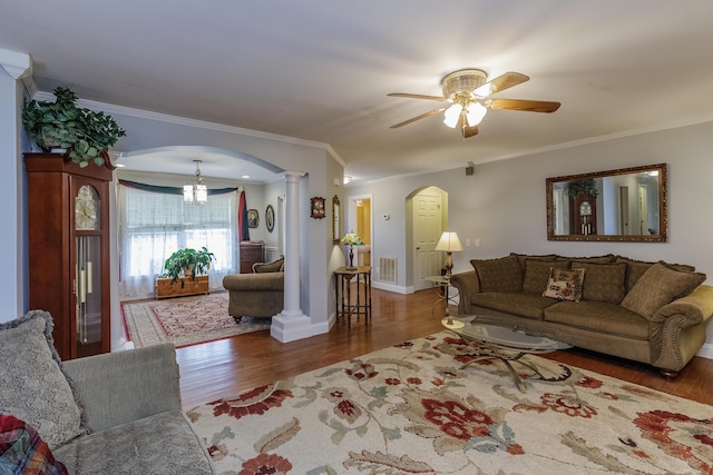 living area featuring visible vents, ornamental molding, ceiling fan with notable chandelier, wood finished floors, and arched walkways