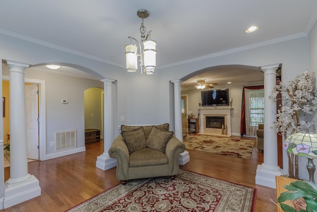 living room with wood finished floors, a fireplace, visible vents, and ceiling fan