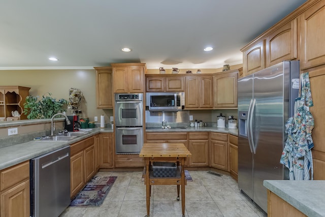 kitchen featuring a sink, light countertops, light tile patterned flooring, and stainless steel appliances