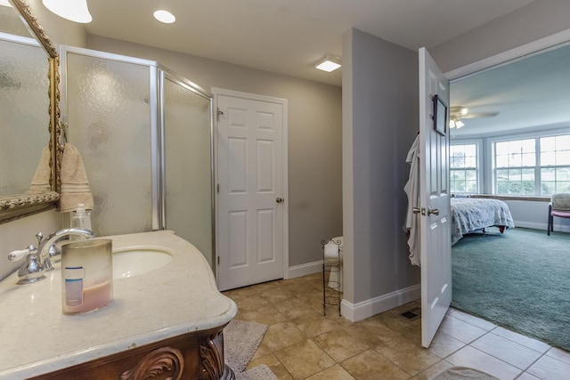 bathroom with a sink, baseboards, a shower stall, and tile patterned flooring