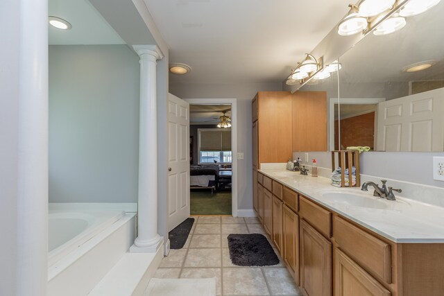 ensuite bathroom with ornate columns, double vanity, a sink, ensuite bathroom, and a bath