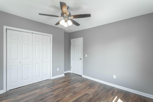 unfurnished bedroom with ceiling fan, a closet, baseboards, and dark wood-style floors