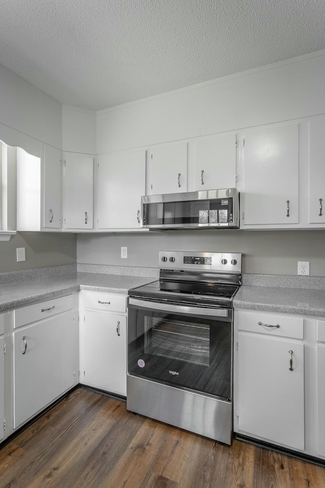 kitchen with stainless steel appliances, light countertops, and dark wood-style flooring