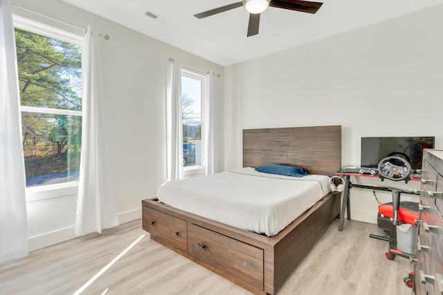 bedroom with visible vents, baseboards, a ceiling fan, and light wood finished floors