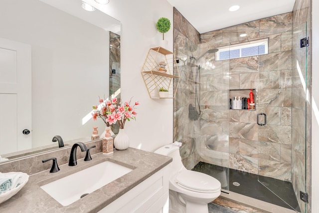 full bathroom with a shower stall, toilet, and vanity