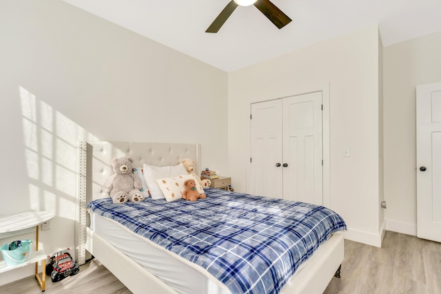 bedroom featuring a closet, a ceiling fan, baseboards, and wood finished floors