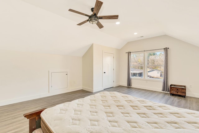 unfurnished bedroom with wood finished floors, baseboards, and vaulted ceiling