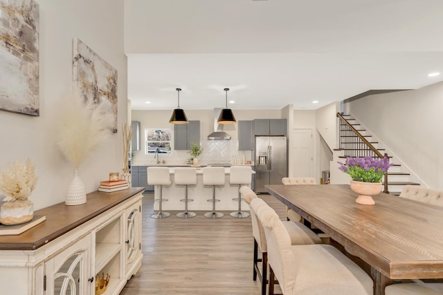 dining space featuring stairway, recessed lighting, and light wood-type flooring