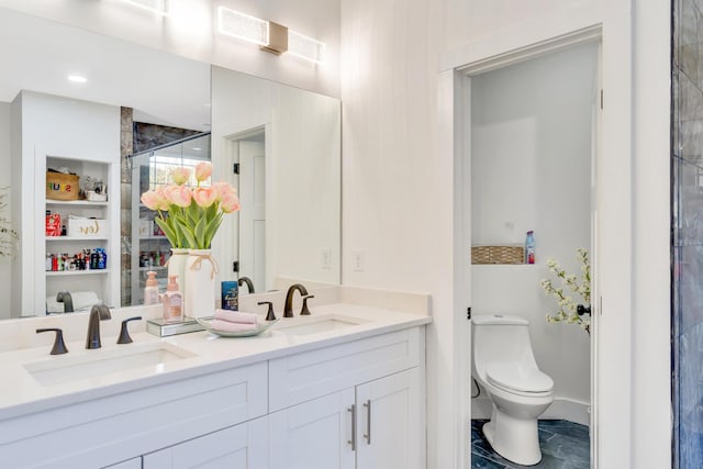 bathroom with double vanity, toilet, and a sink