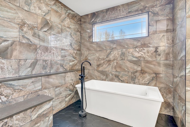 full bathroom featuring tile patterned floors, a freestanding bath, and tile walls