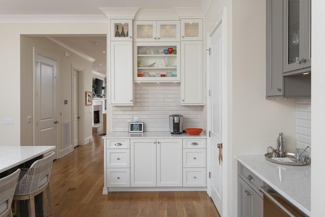 778 Latitude Cir, Chattanooga, TN 37402 - kitchen with backsplash, light stone counters, gray cabinetry, light wood finished floors, and glass insert cabinets