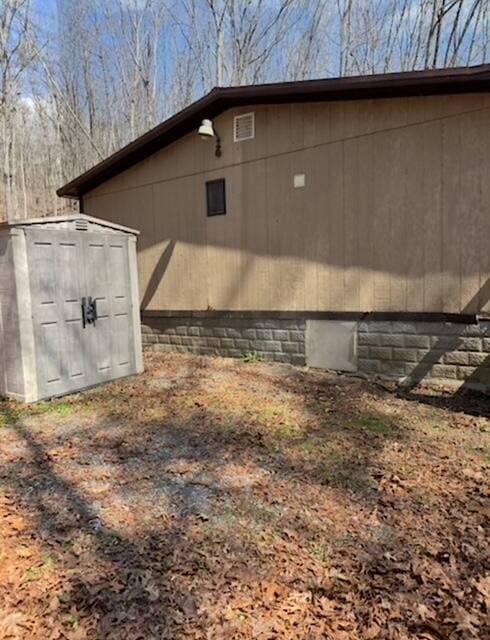 view of side of home featuring an outbuilding and a storage shed