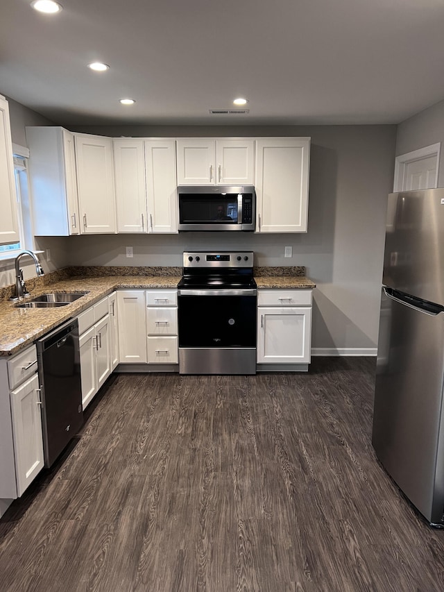 kitchen featuring dark wood-style flooring, white cabinets, stainless steel appliances, and a sink