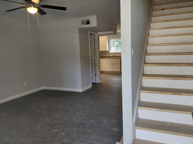 staircase featuring visible vents, baseboards, concrete flooring, and ceiling fan